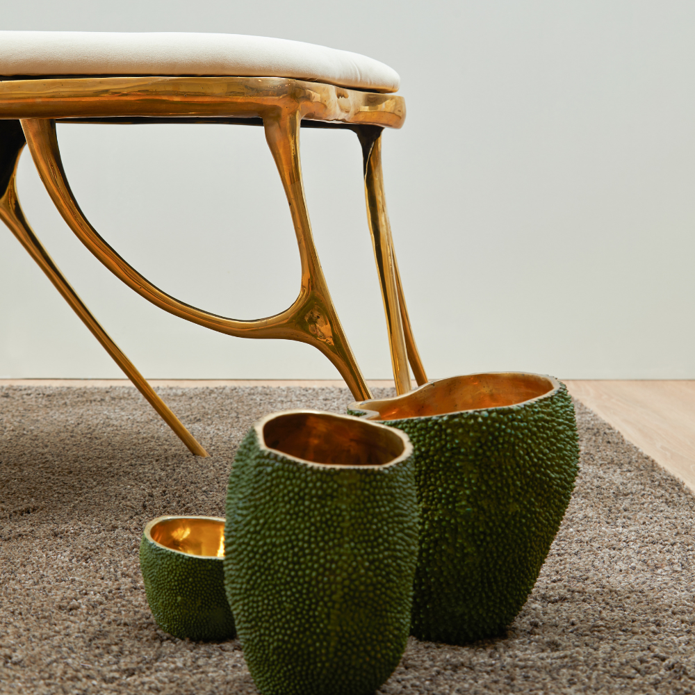 Decorative green planters with gold interior on a textured surface