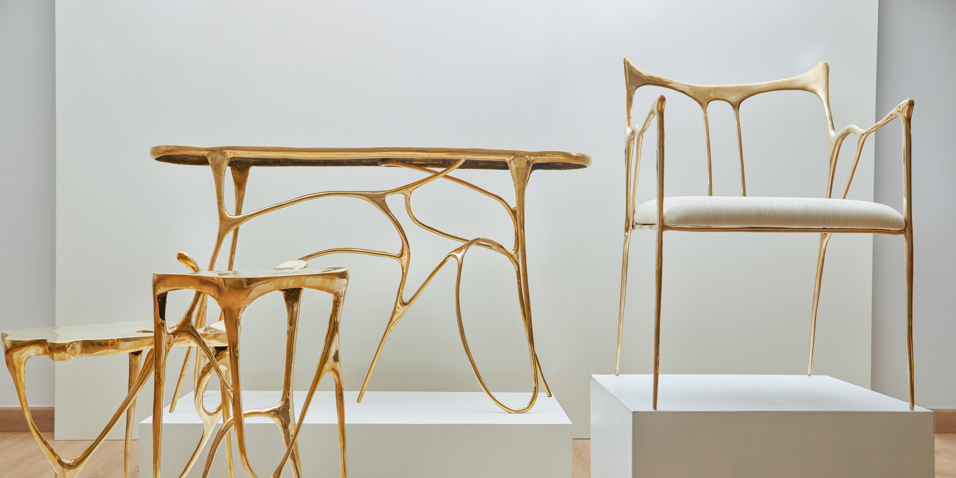 Gold metal furniture set including a table and chairs on a white background